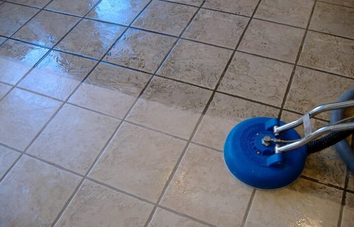 Technician cleaning grout on Dubai tile floor