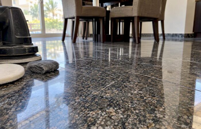 Scratched polished granite floor beside repair pads